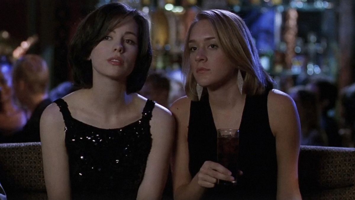 two women sitting next to each other at night club