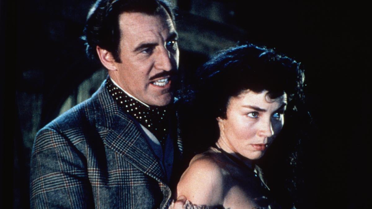 woman standing in front of man with his arms holding her