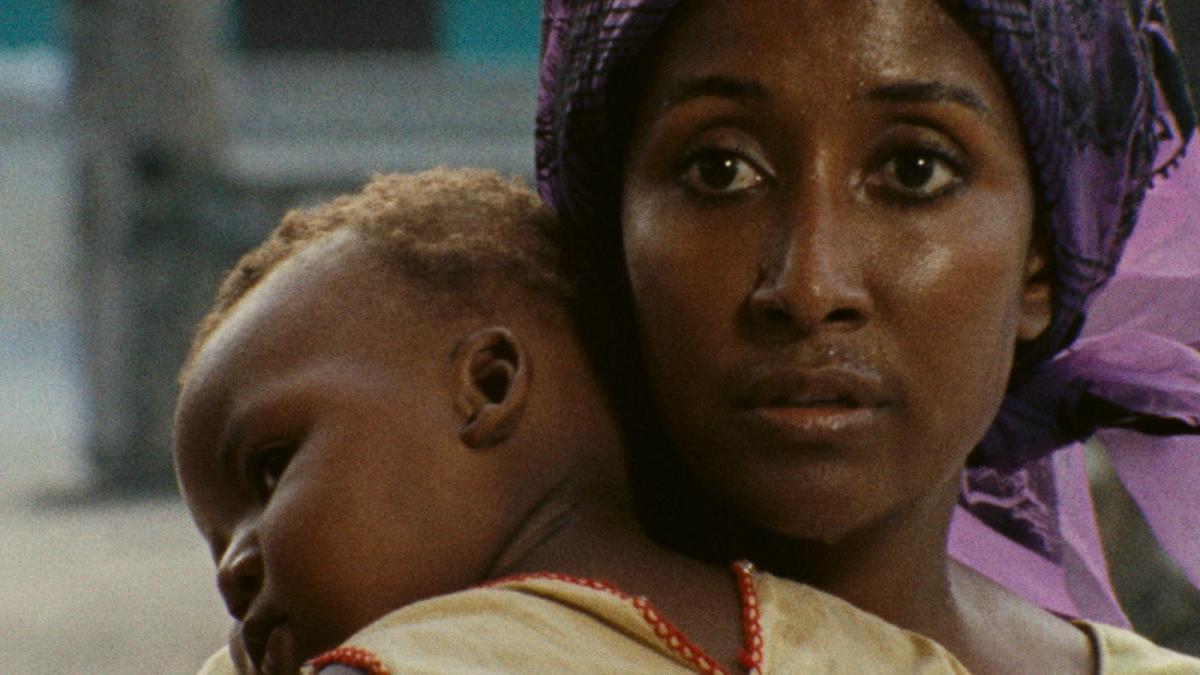 black woman holding young baby sleeping on shoulder