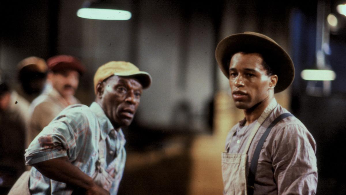 two black men in overalls and hats at work