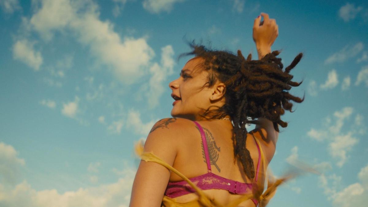 woman in bathing suit with hair flying around and arm up