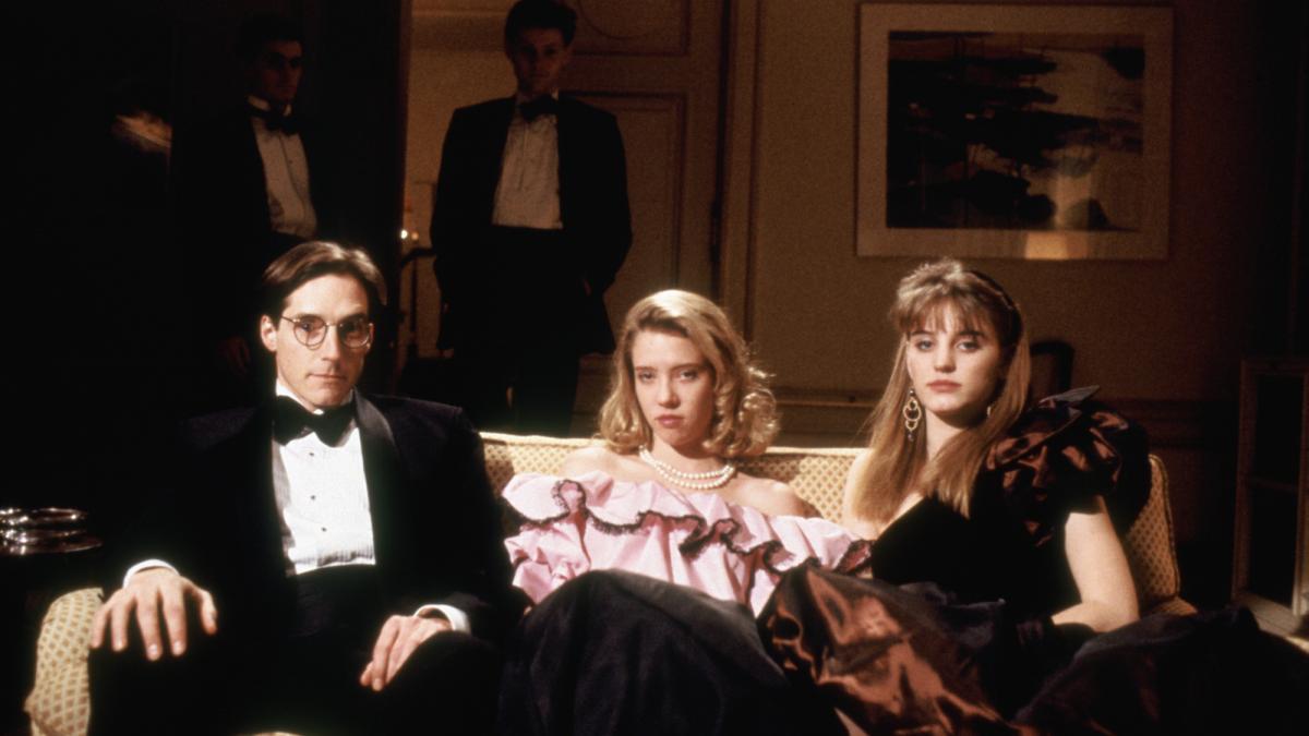 three young people in formal wear sitting on couch