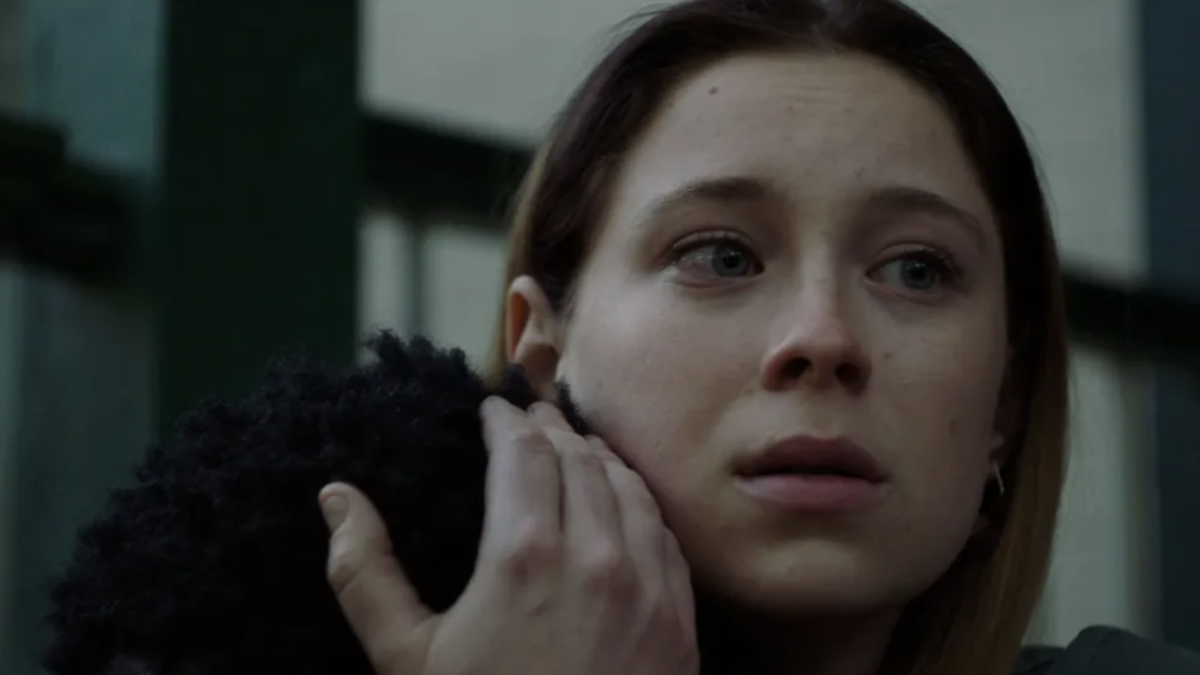 woman hugging person's head and looking into the distance