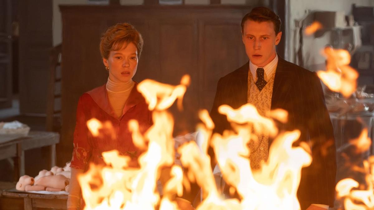 man and woman in formalwear standing and staring at small fire
