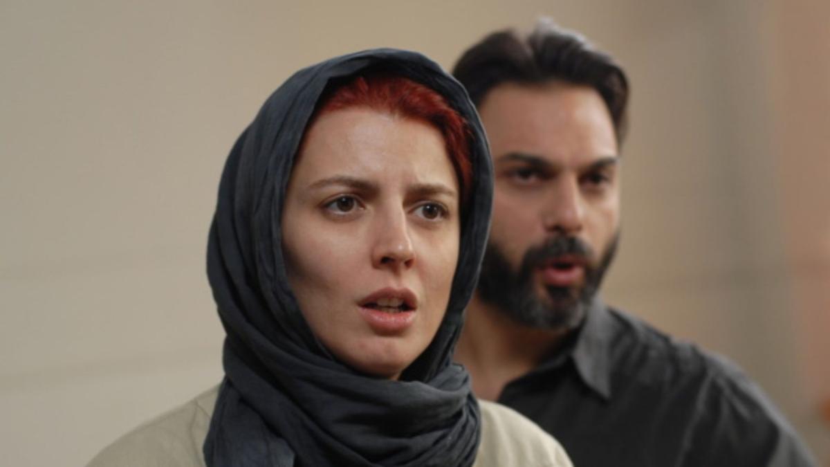 woman wearing a hijab standing next to man