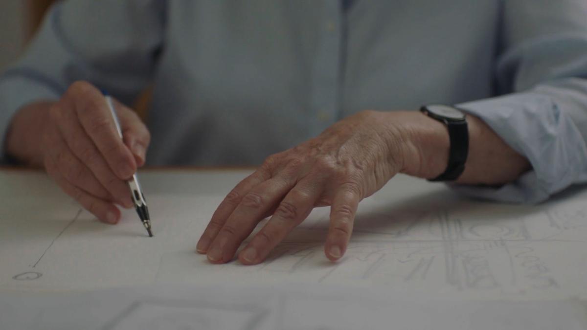 woman's hands sketching blueprints