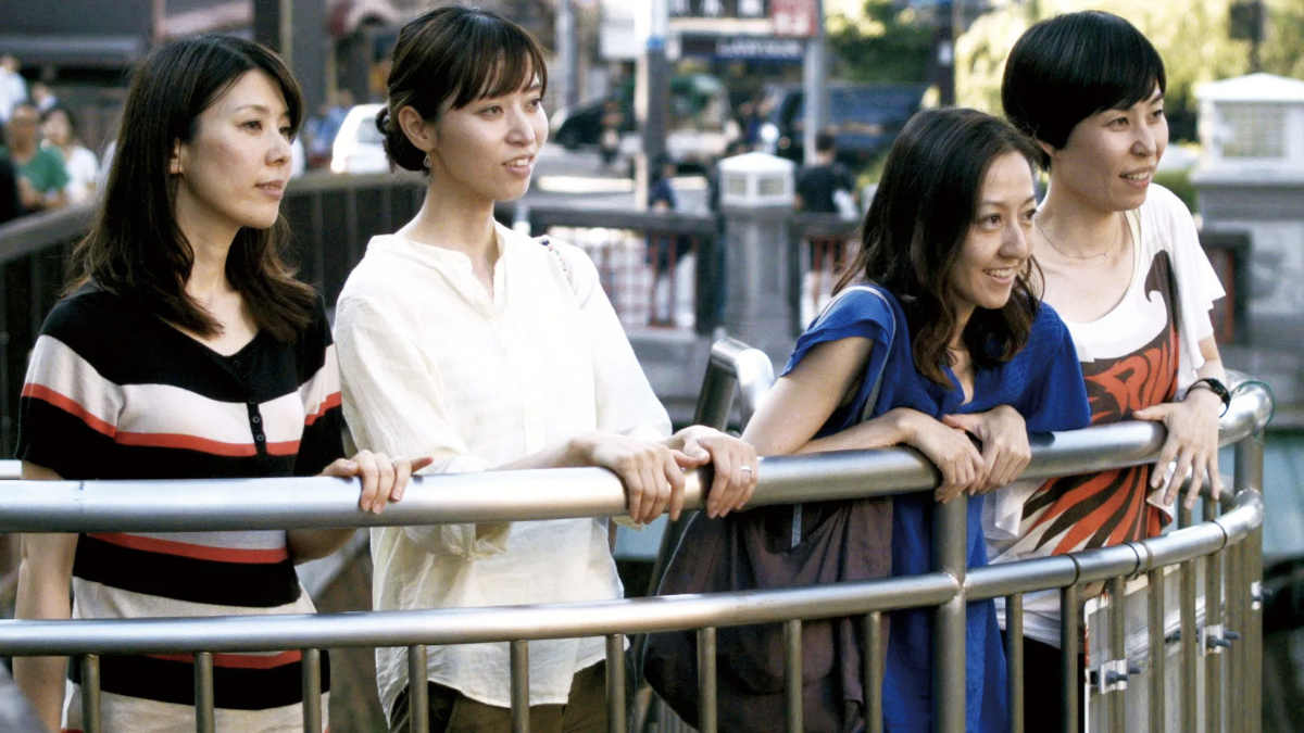 group of woman leaning over fence smiling