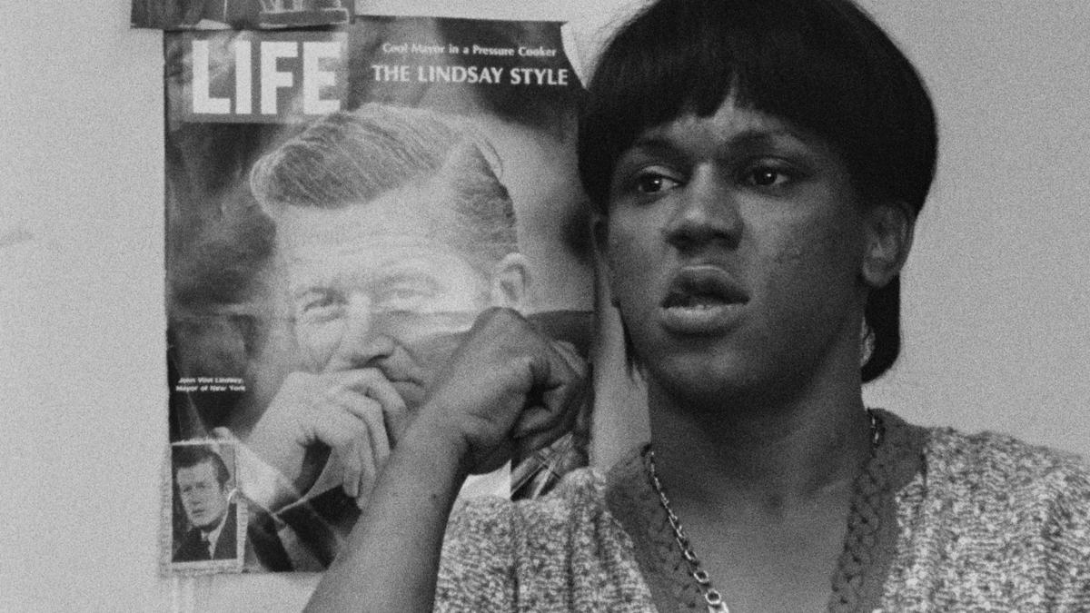 woman seated in front of wall with life magazine hung on wall