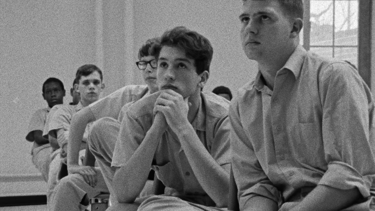 row of boys in prison uniforms seated in room