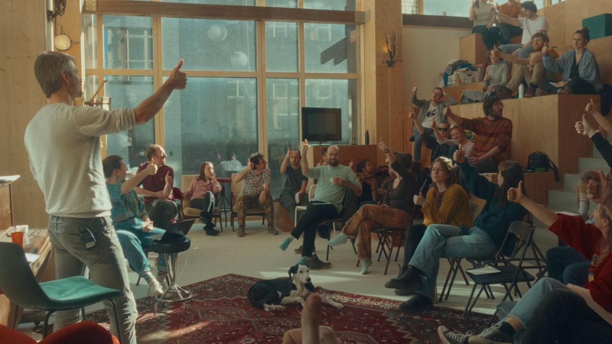 classroom with professor holding a thumbs up and students following