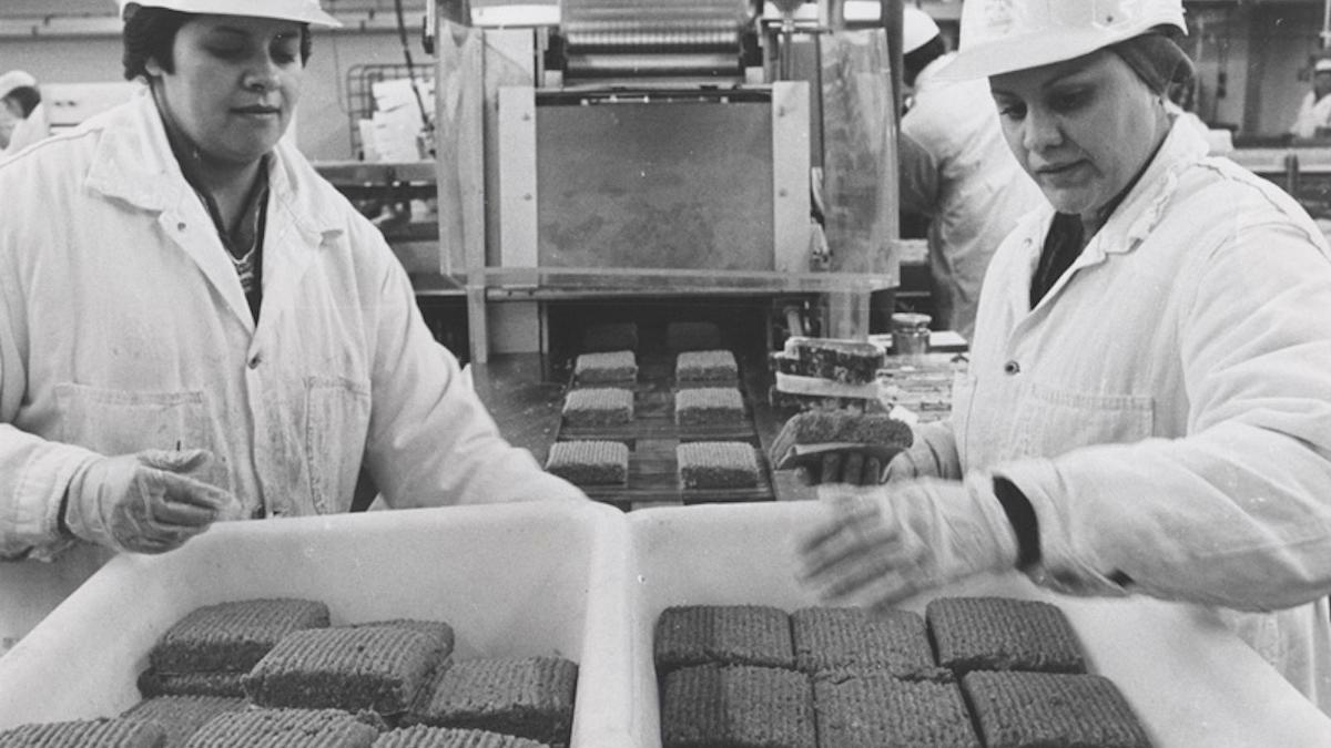 two women in factory packing meat