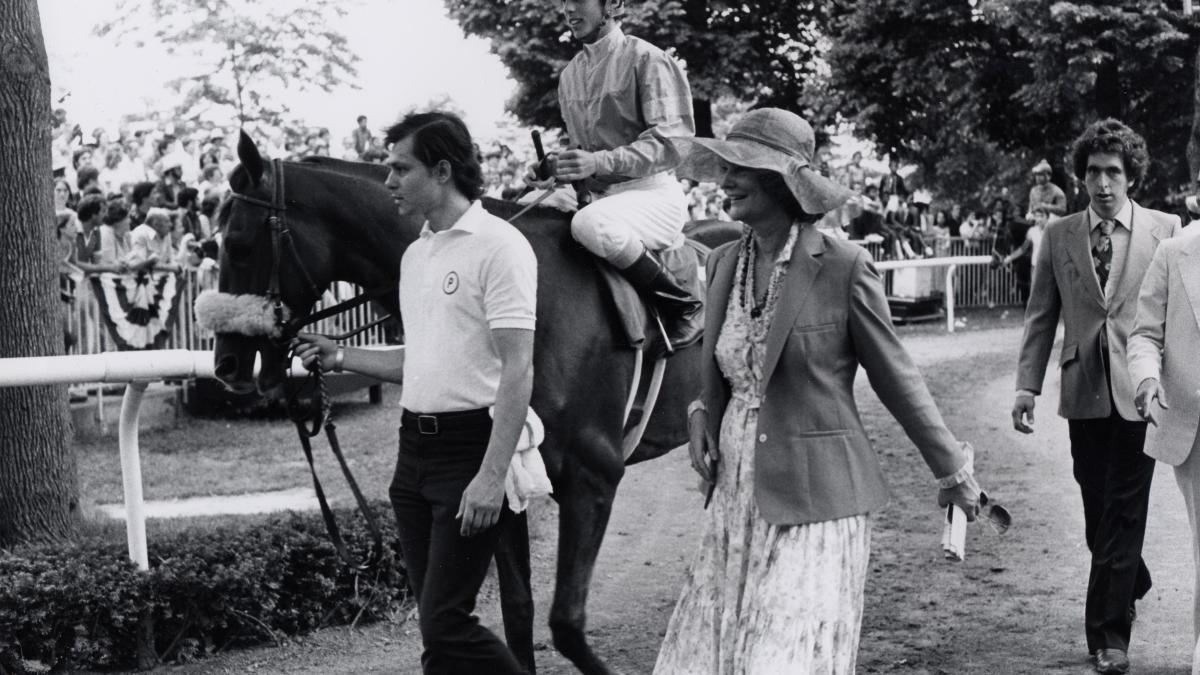 man and woman at horse track leading horse