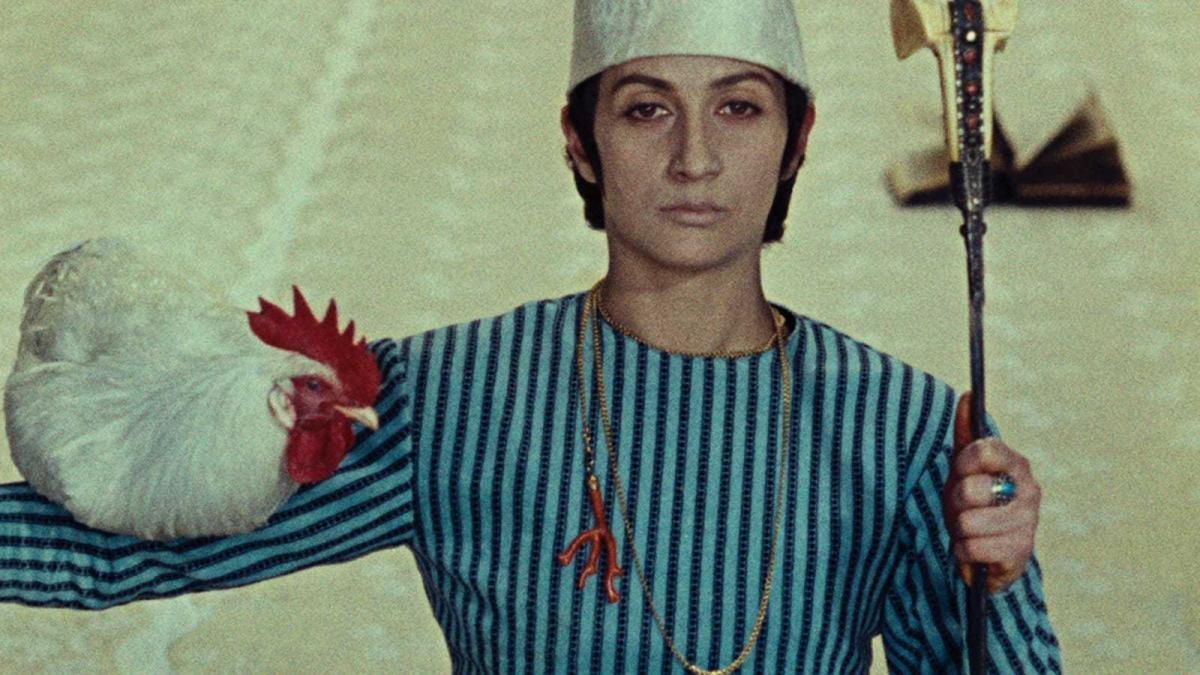 man in striped uniform holding up chicken