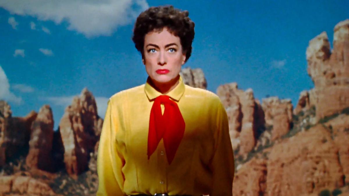 woman in yellow shirt and red kerchief standing in dessert
