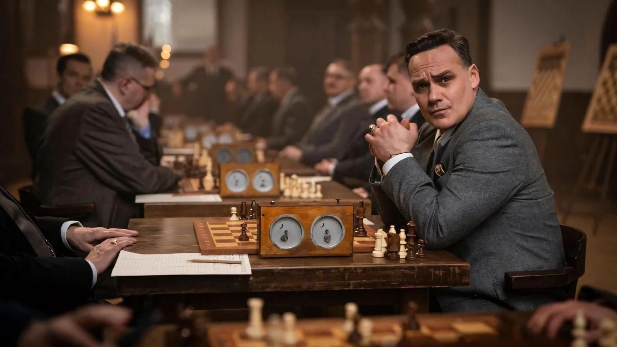 men seated on wood tables in chess tournament