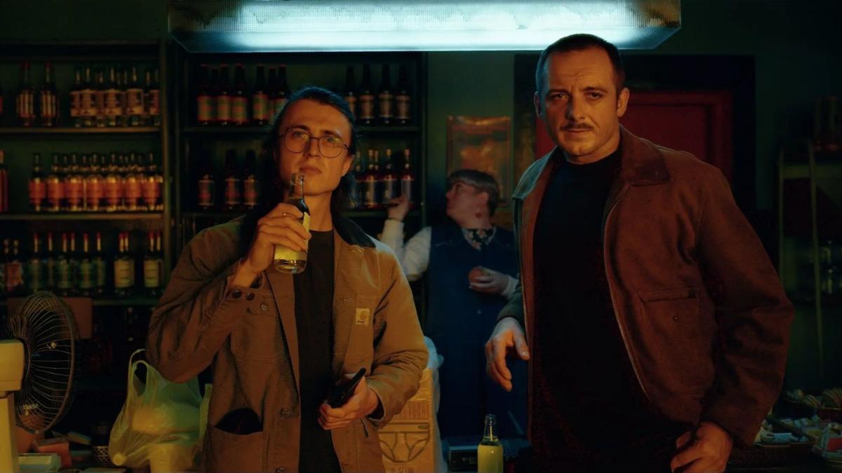 two men standing at bar