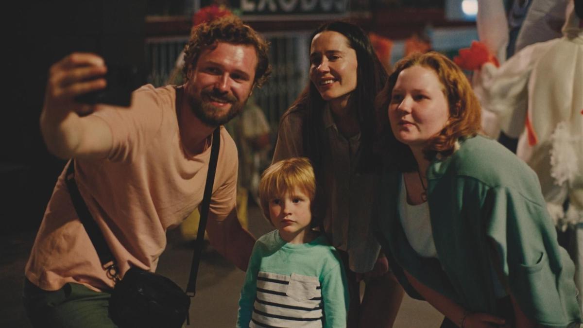 family standing in the street posing for a selfie