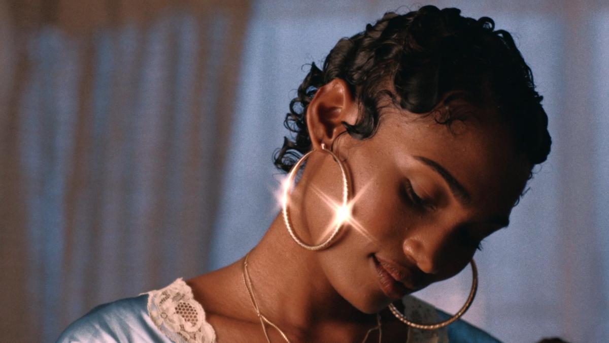 woman with short hear and gold hoop earrings looking down