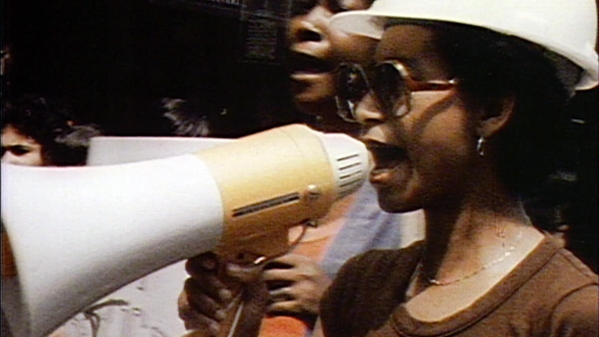 BORN IN FLAMES, 1983, woman wearing hardhat holding megaphone up to mouth