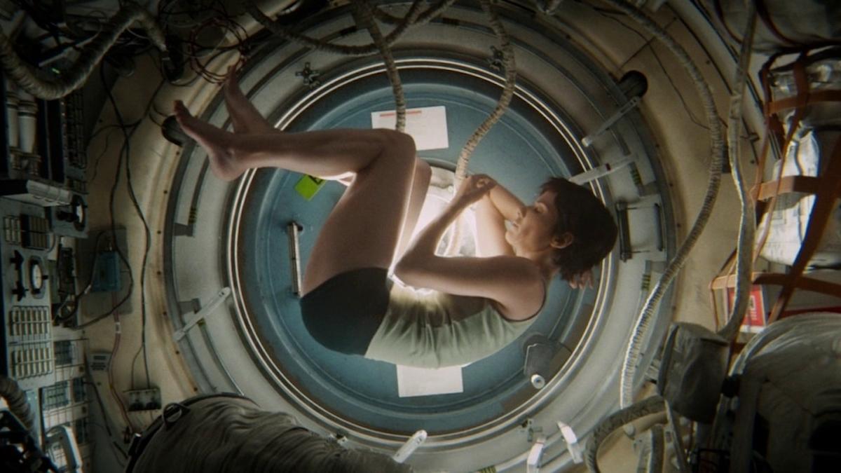 GRAVITY, 2013, woman in fetal position floating in spaceship pod