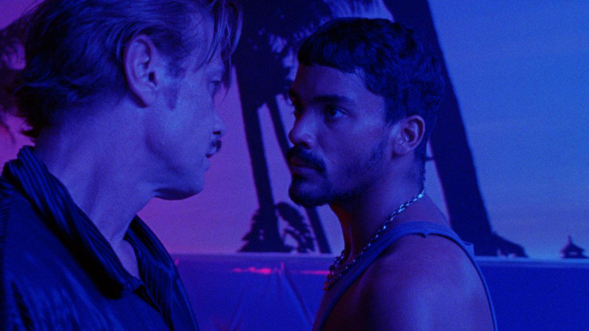 MOTEL DESTINO, 2024, two men in purple-lit club room locking eyes