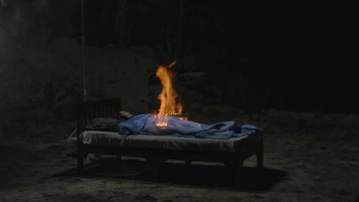 BLUE, 2018, woman lying on bed on beach at night with flame rising from her chest