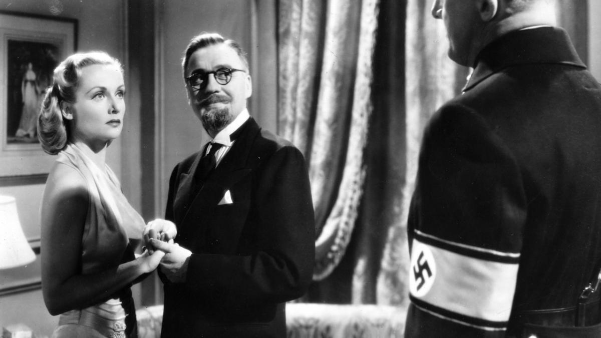 TO BE OR NOT TO BE, 1942, man and woman in formalwear holding hands and looking towards man with Nazi armband