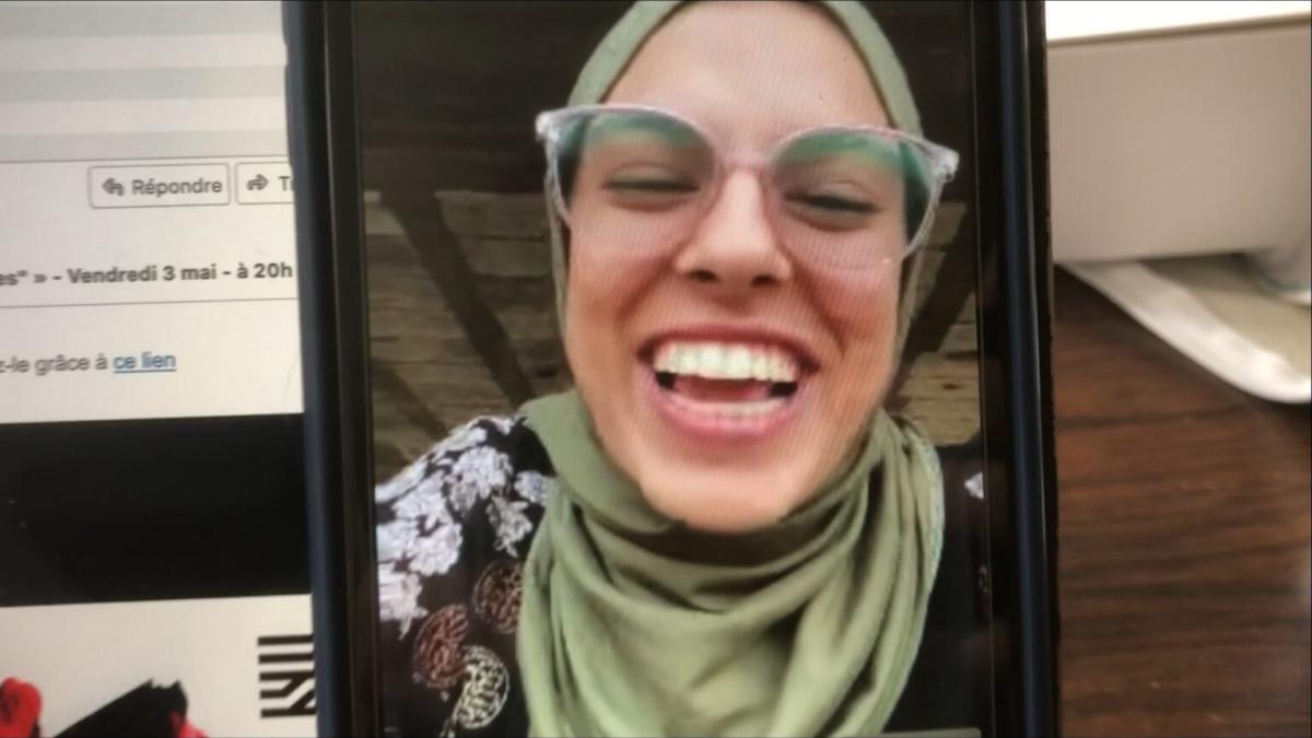 PUT YOUR SOUL ON YOUR HAND AND WALK, 2025, image of woman wearing green hijab and glasses on phone screen