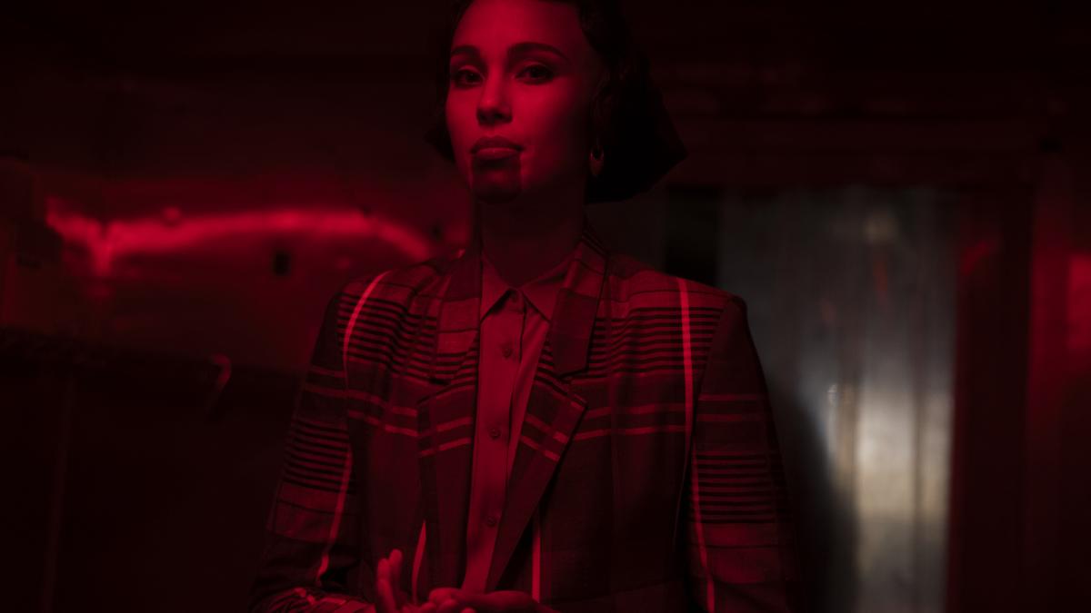 BLKNWS, 2025, woman standing in plaid blazer with red lighting