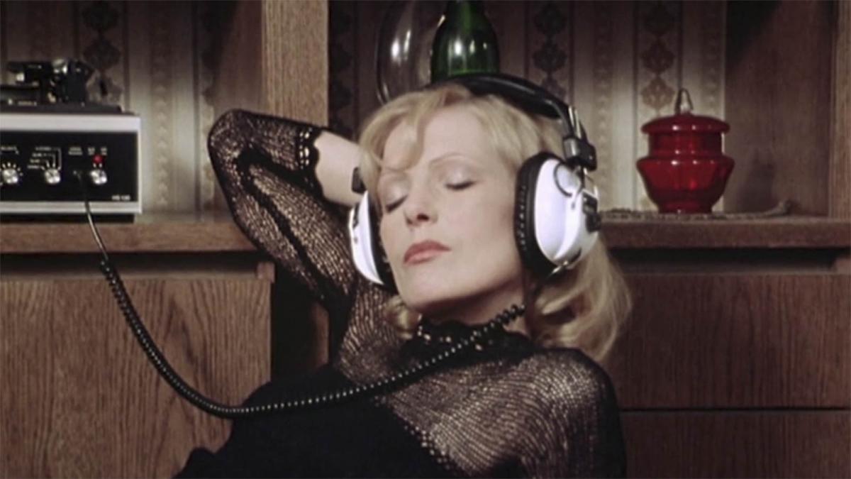 FEAR OF FEAR, 1975, blonde woman wearing over the ear headphones with eyes closed and hand behind head