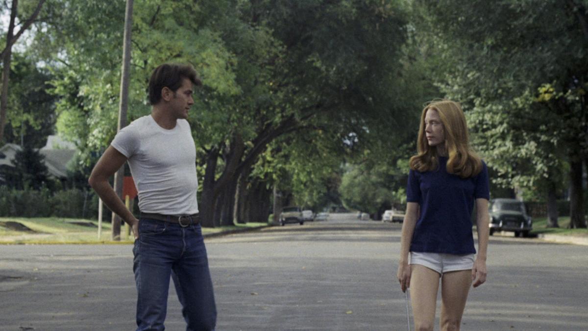 BADLANDS, 1973, man in white t-shirt and blue jeans walking down street with girl in blue shirt and white shorts