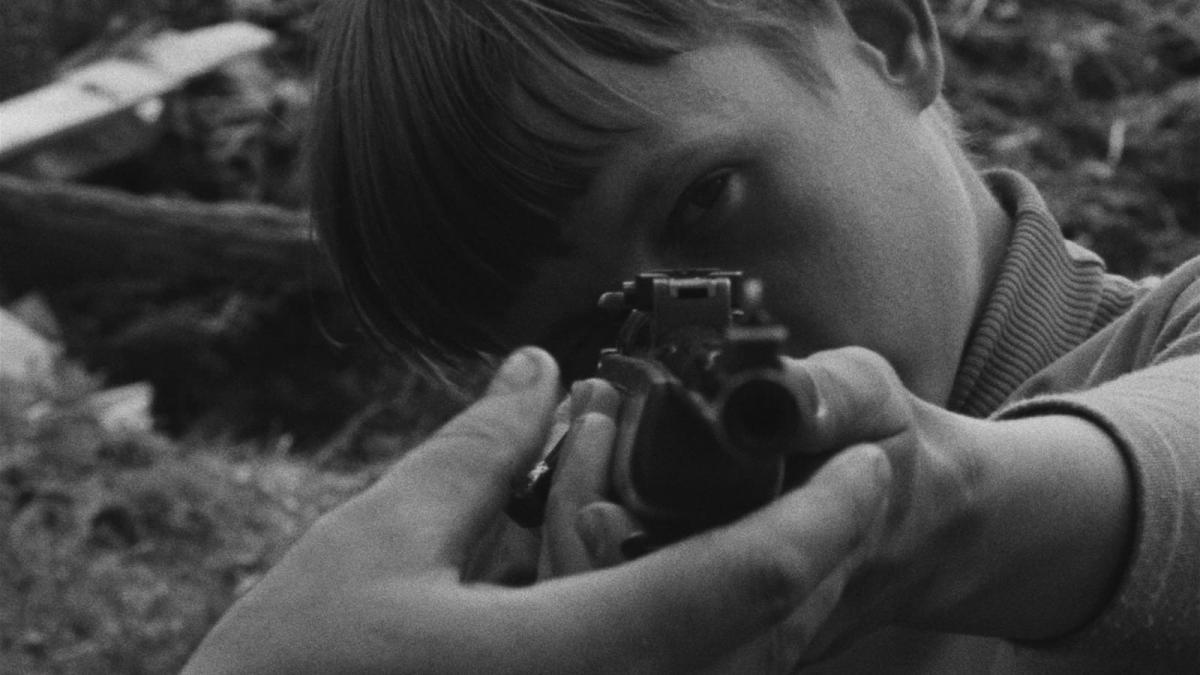 EIGHT DEADLY SHOTS, 1972, black and white still of person holding and pointing gun with another hand holding steady