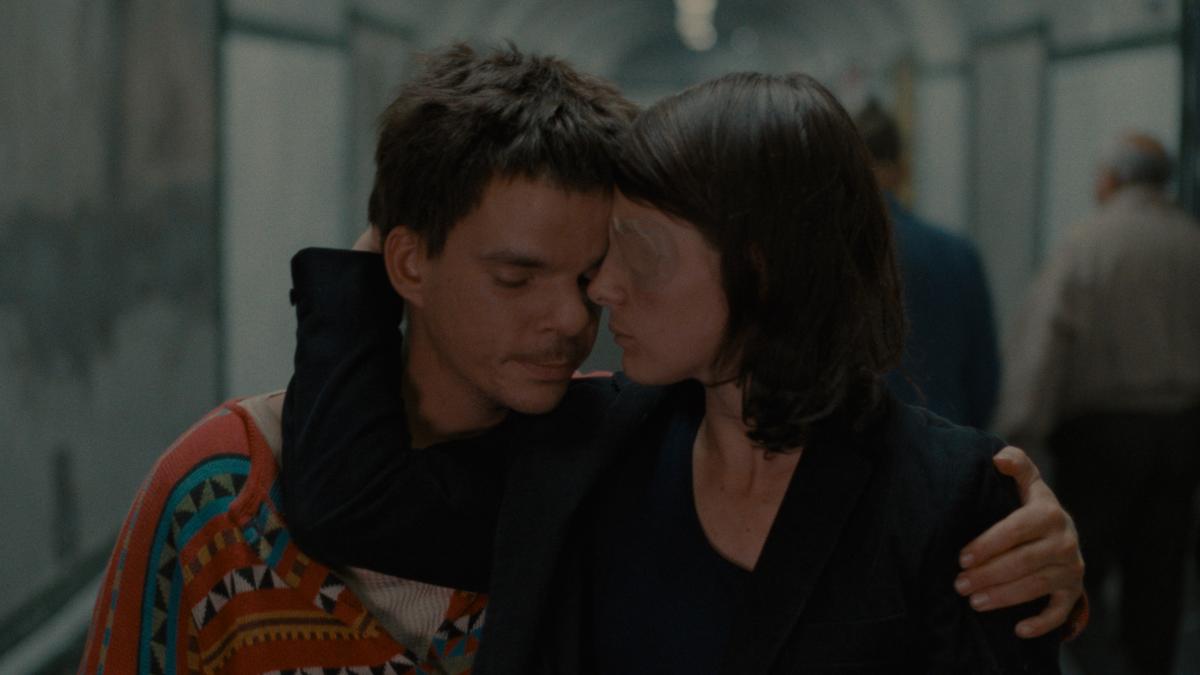 THE LOVERS ON THE BRIDGE, 1991, man and woman on train with woman wrapping arm around man's face