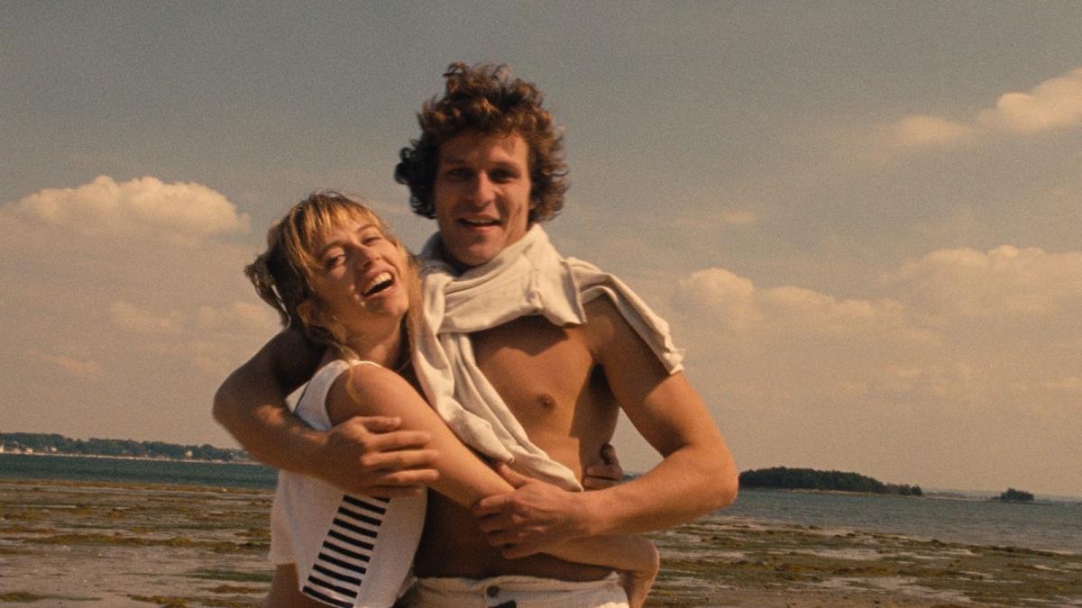 TALES OF THE FOUR SEASONS, 1990-1998, man and woman embracing on beach wearing swimsuits and sweaters