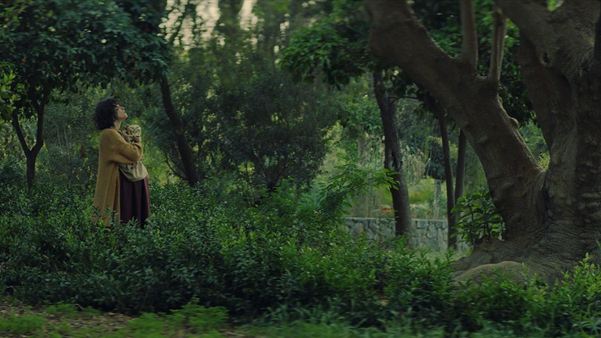 EMBRYO LARVA BUTTERFLY, 2023, woman standing in woods looking towards sky with eyes closed