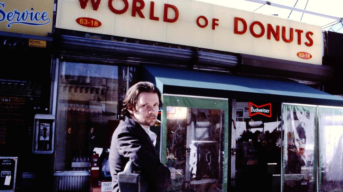HENRY FOOL, 1997, man in leather jacket on street in front of storefront turning around and looking towards camera