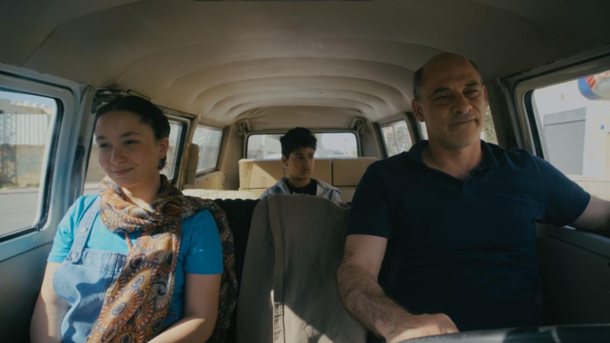 PASSING DREAMS, 2024, man in driver's seat with woman riding beside him in passenger seat and boy in the back seat