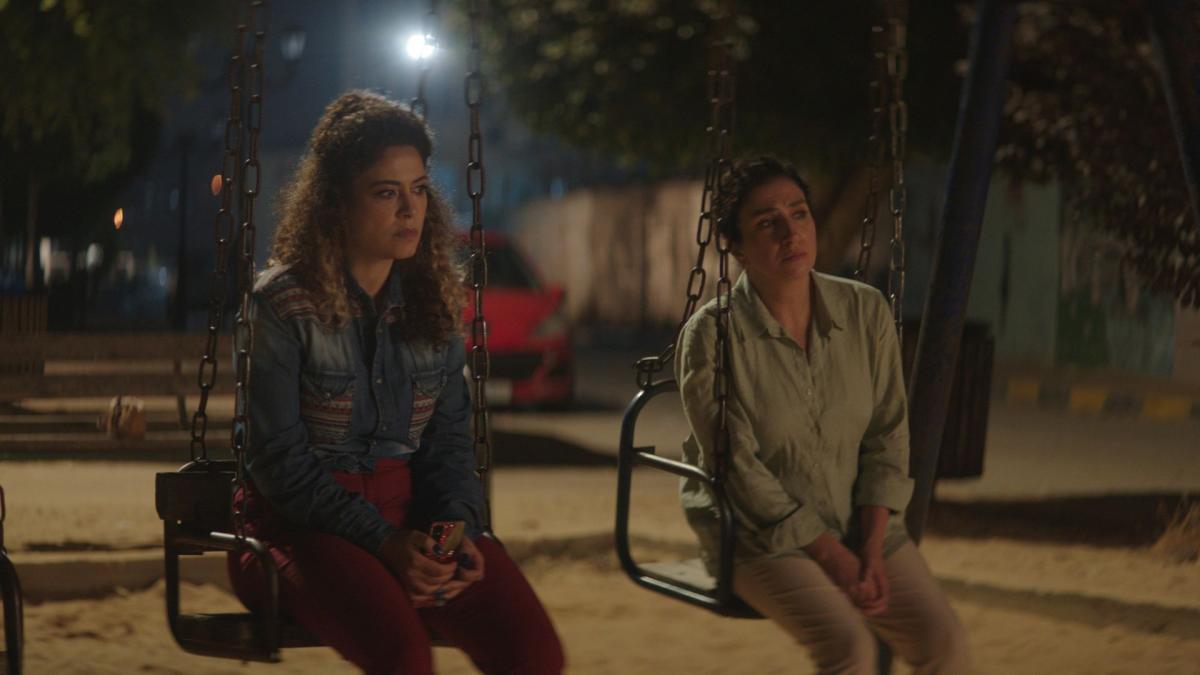 THANK YOU FOR BANKING WITH US, 2025, two women seated on park swings at night