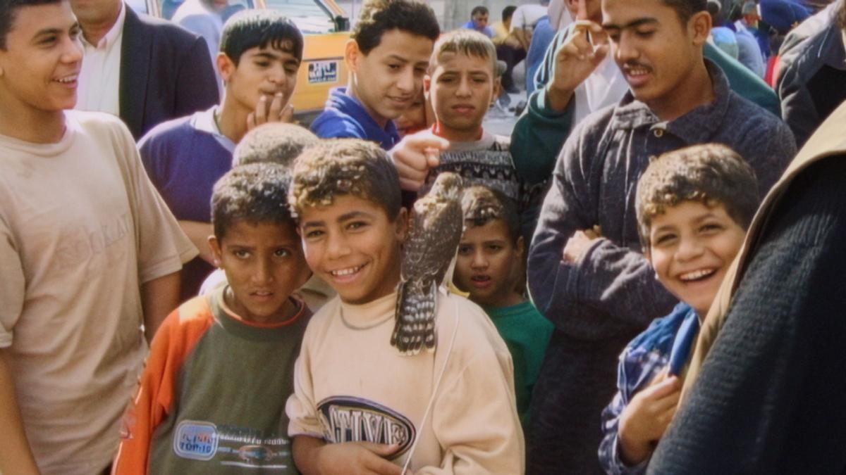 WITH HASAN IN GAZA, 2025, two young boys with arms around each other smiling in large crowd