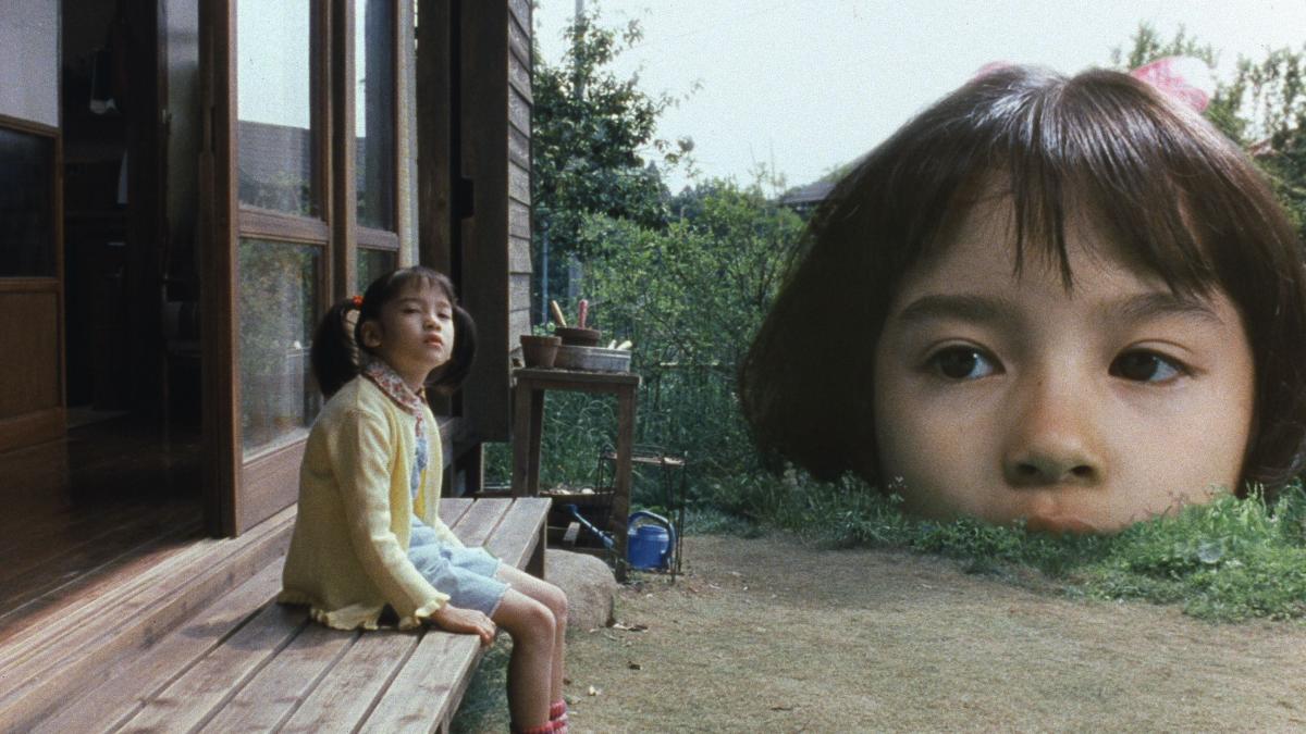 THE TASTE OF TEA, 2004, young Japanese girl sitting on bench with a large surreal version of her face rising from the ground in the background