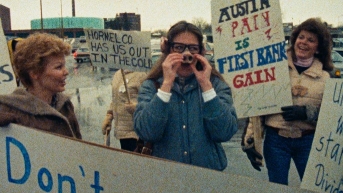 AMERICAN DREAM, 1990, young people standing outside protesting with signs and props