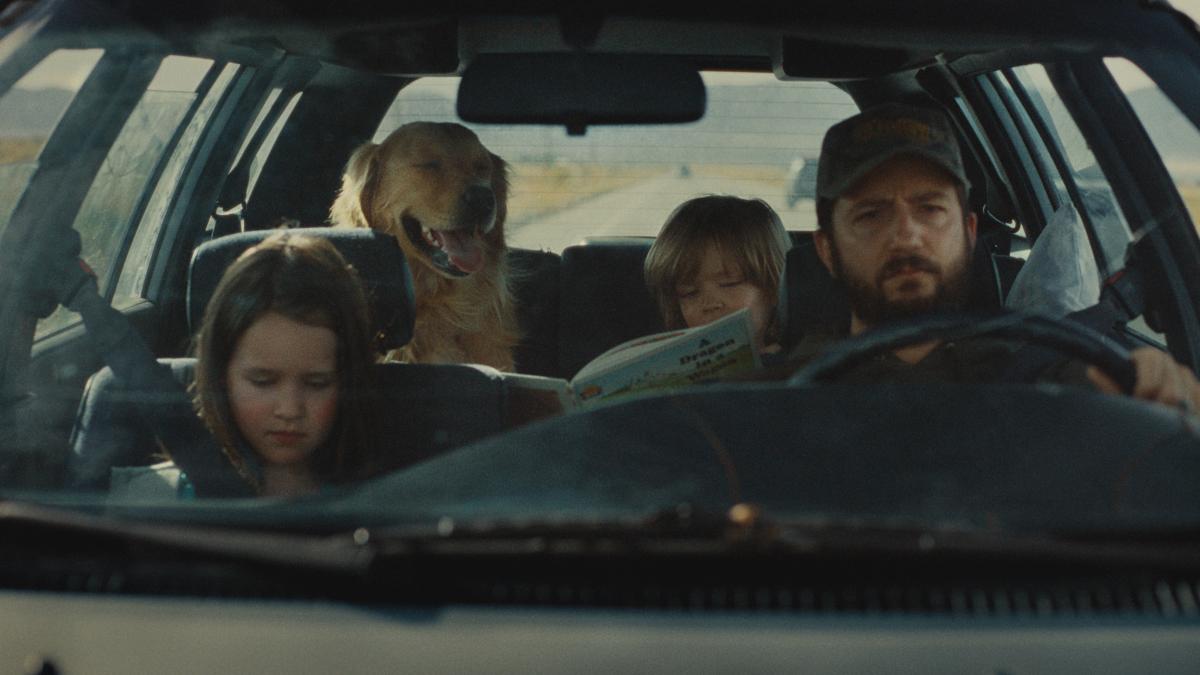 OMAHA, 2025, family in car with dad driving, girl in front seat, son and golden retriever in backseat