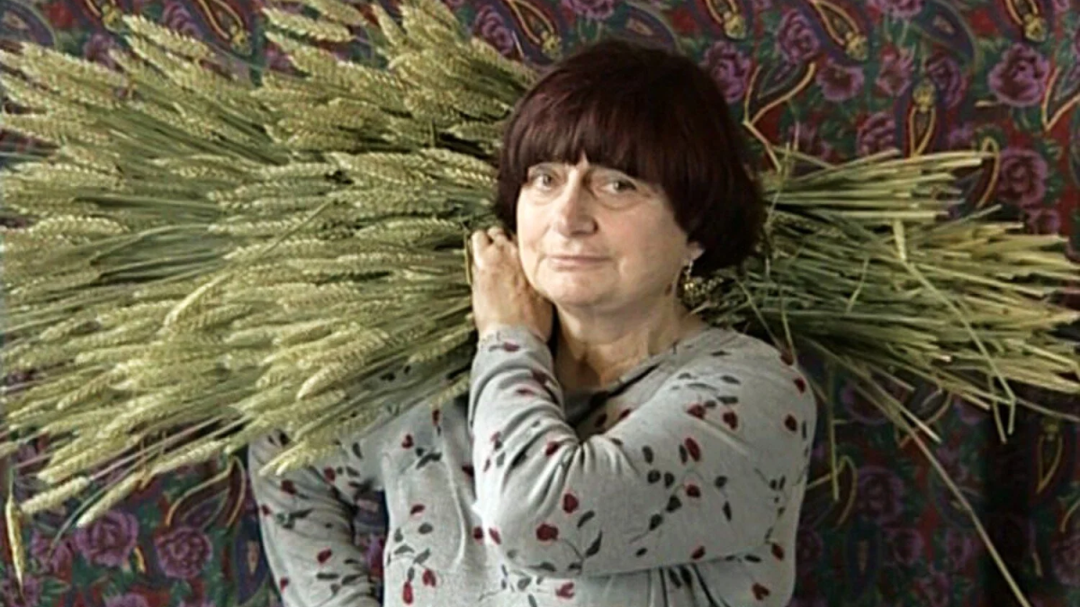 THE GLEANERS AND I, 2000, agnes varda holding bundle of plants and branches over her shoulder