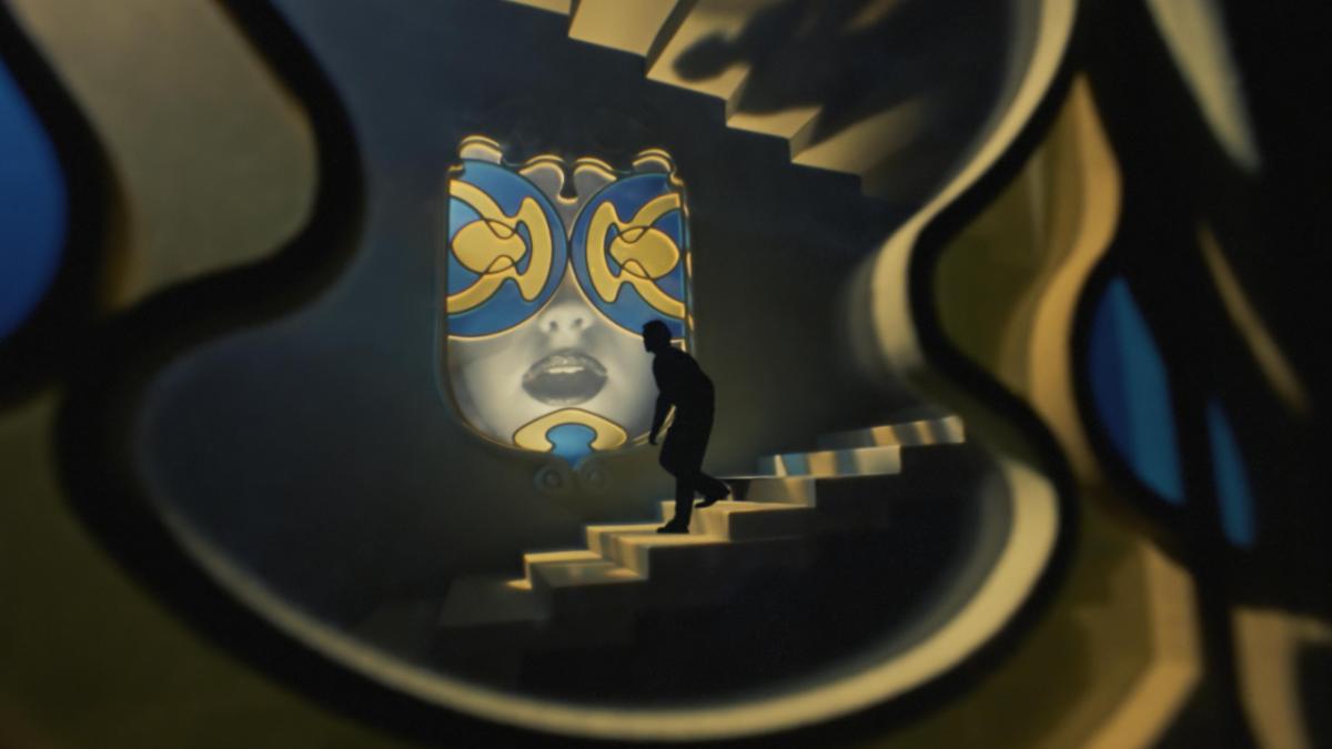 ORFEO, 2025, silhouette of man sneaking down large staircase with large, lit mask hanging on wall