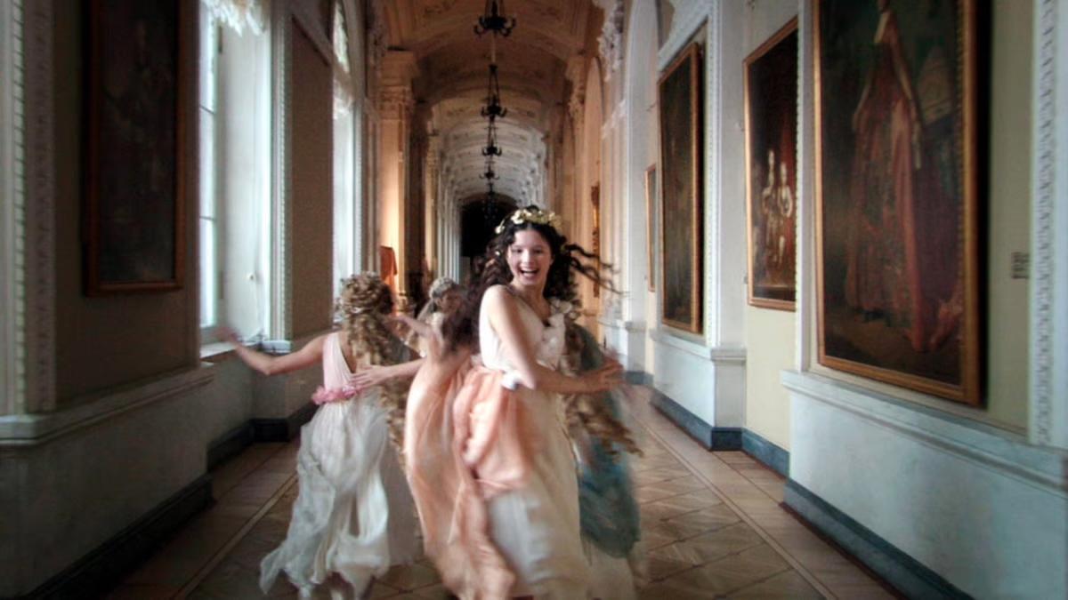 RUSSIAN ARK, 2002, two young girls running through hall of grand looking building wearing lightly colored dresses