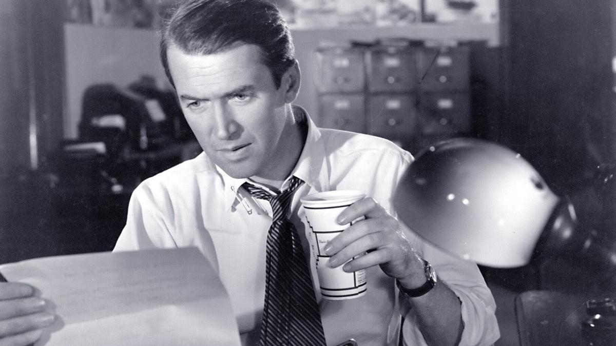 CALL NORTHSIDE 777, 1948, James Stewart holding cup of coffee at desk and looking intently at piece of paper in his hand