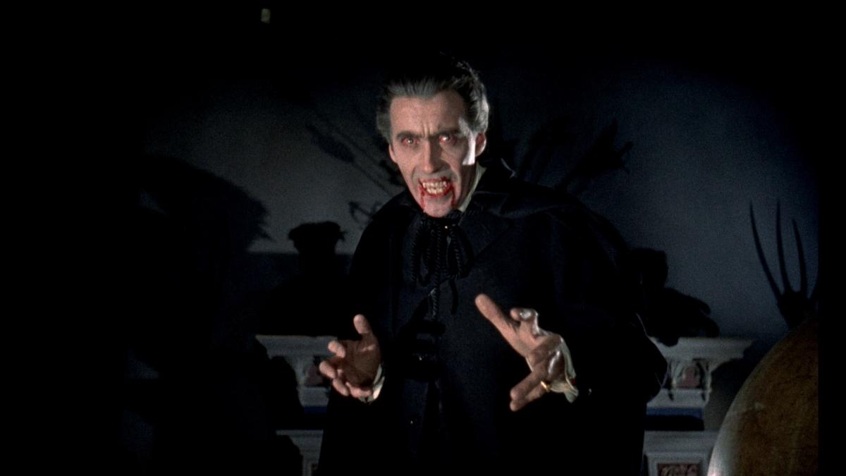 HORROR OF DRACULA, 1958, vampire man standing in dark with arms out in front of him and mouth open bearing teeth