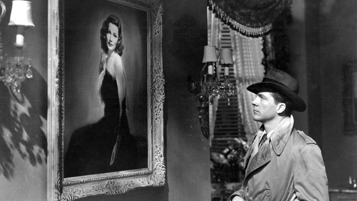 LAURA, 1944, black and white image of man in coat and hat gazing at portrait of a woman