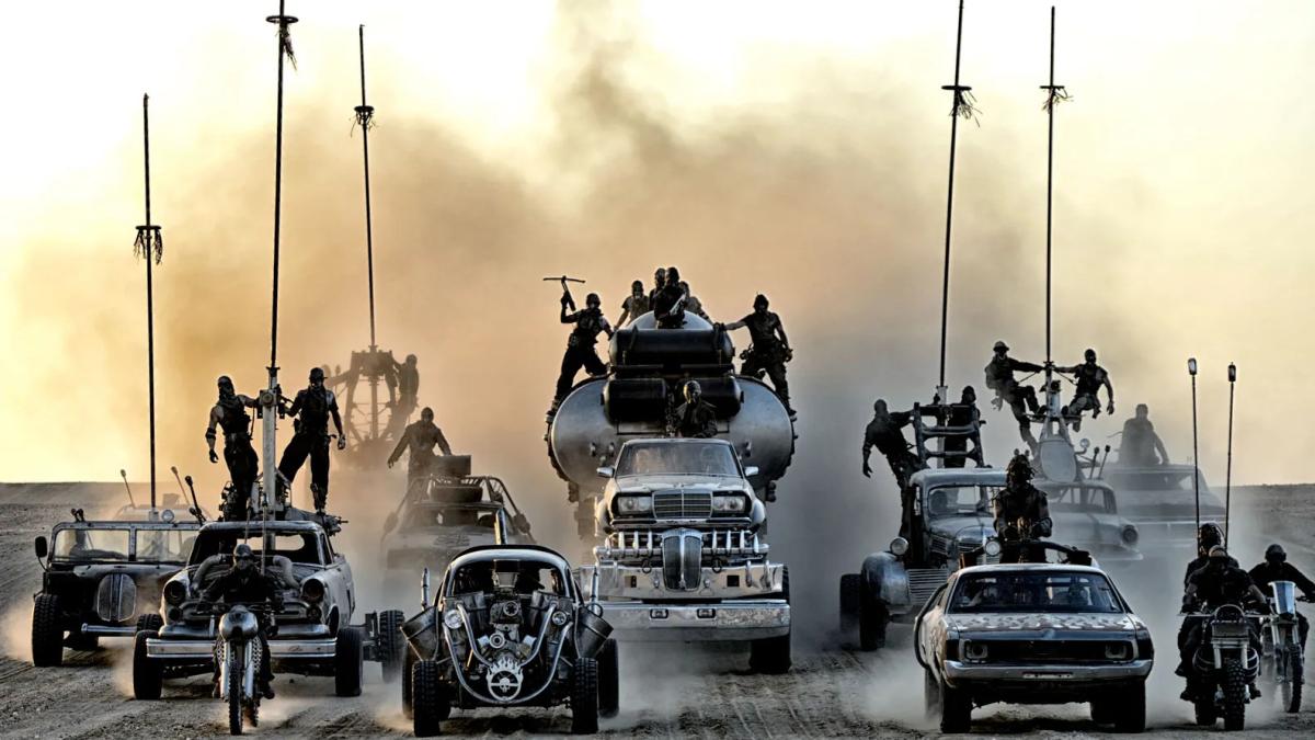 MAD MAX FURY ROAD, 2015, large brigade of cars and vehicles driving in a pack with smoke behind them