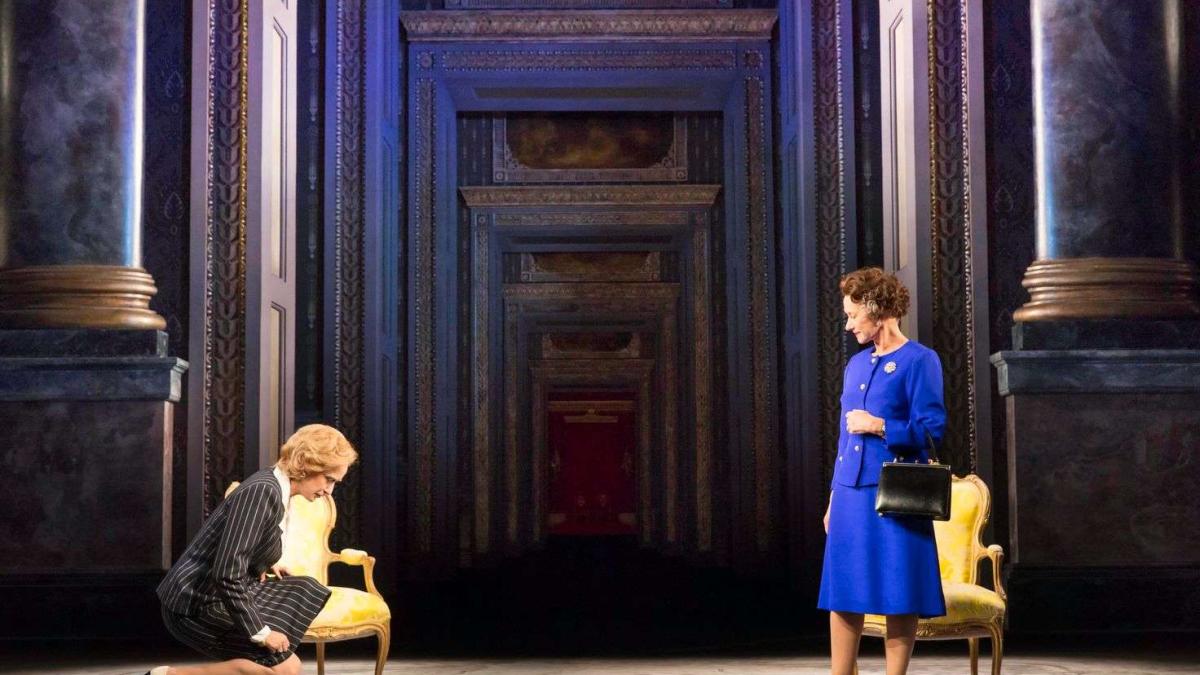 National Theatre Live: THE AUDIENCE, 2013, man kneeling with woman in blue skirt suit standing across from him